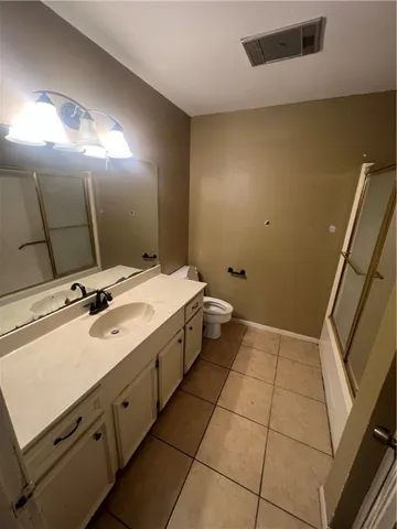 a spacious bathroom with a double vanity sink toilet and a mirror