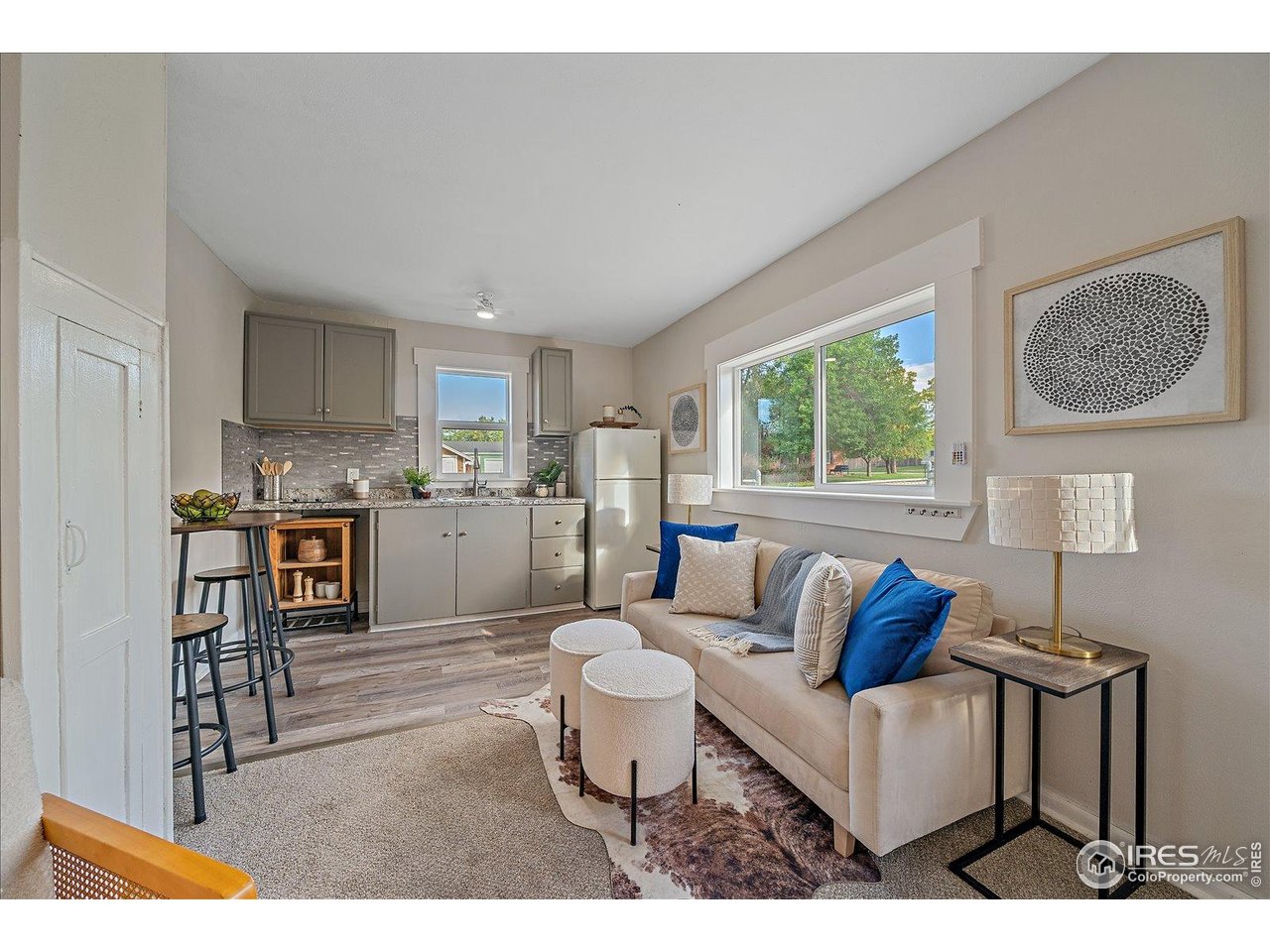131 3rd Street Dacono, CO 80514 - Photo 20 of 28 a living room with furniture a window and kitchen view
