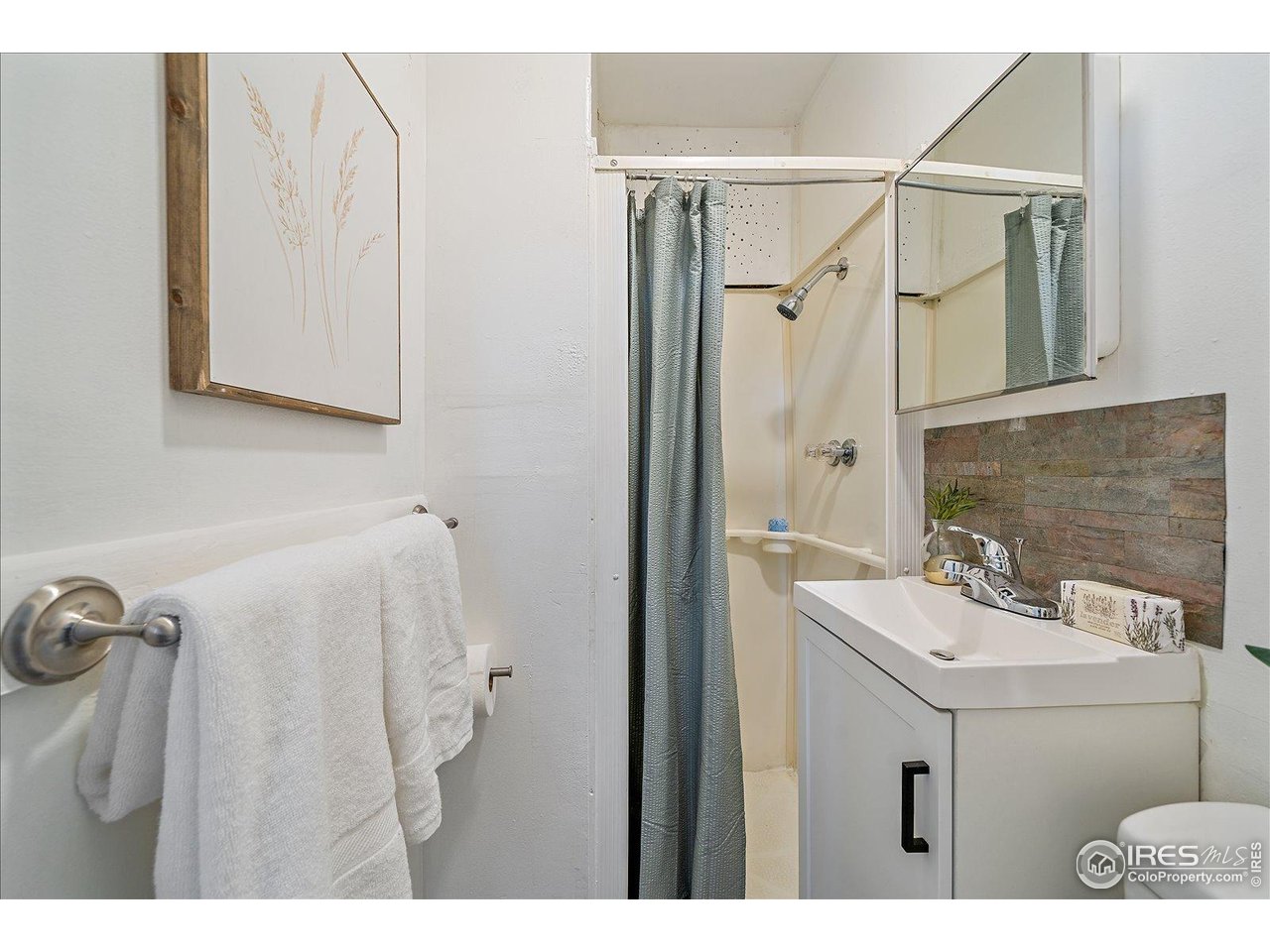 131 3rd Street Dacono, CO 80514 - Photo 25 of 28 a bathroom with a sink mirror and shower