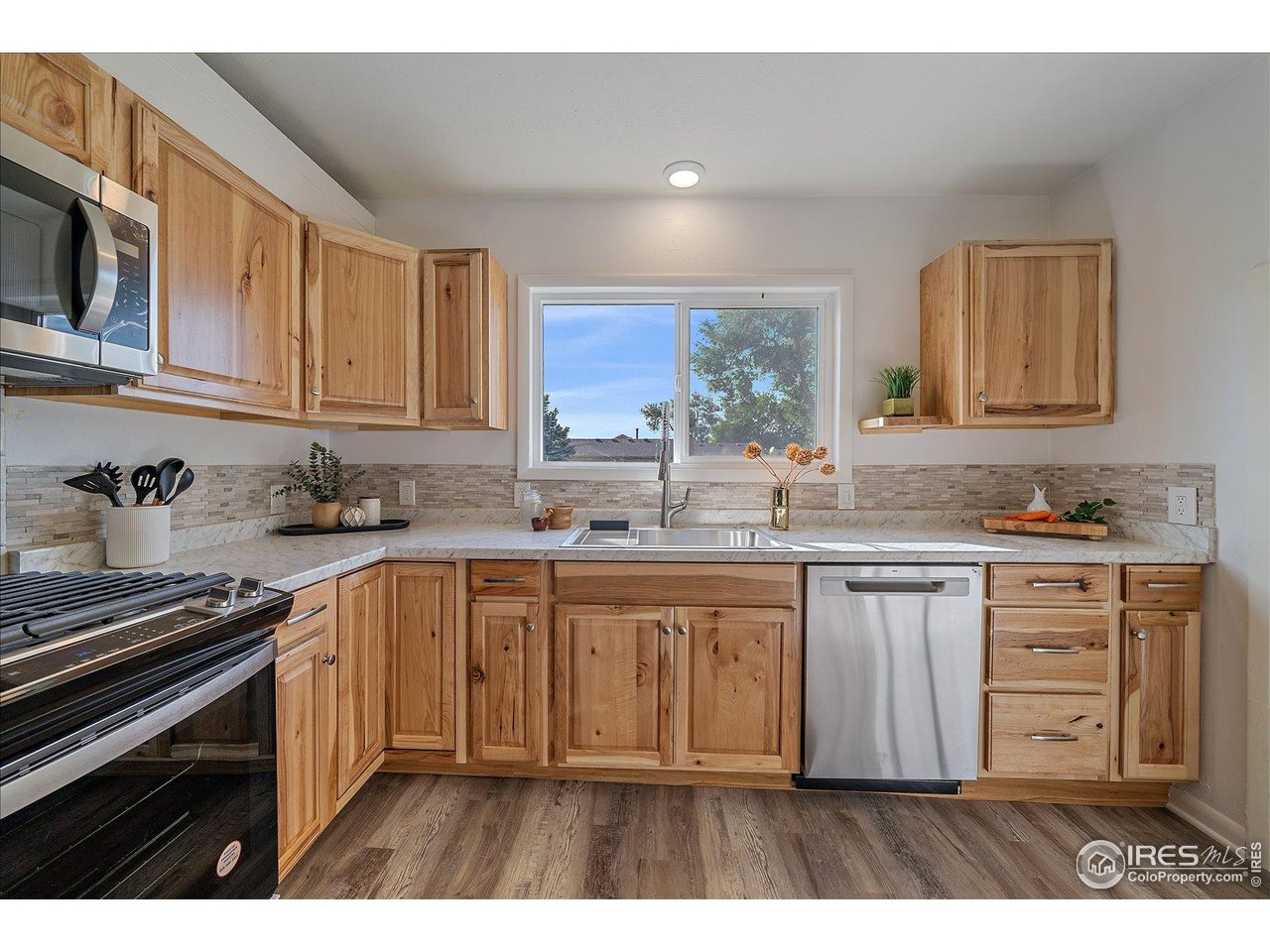 131 3rd Street Dacono, CO 80514 - Photo 8 of 28 a kitchen with stainless steel appliances granite countertop a stove a sink and a microwave