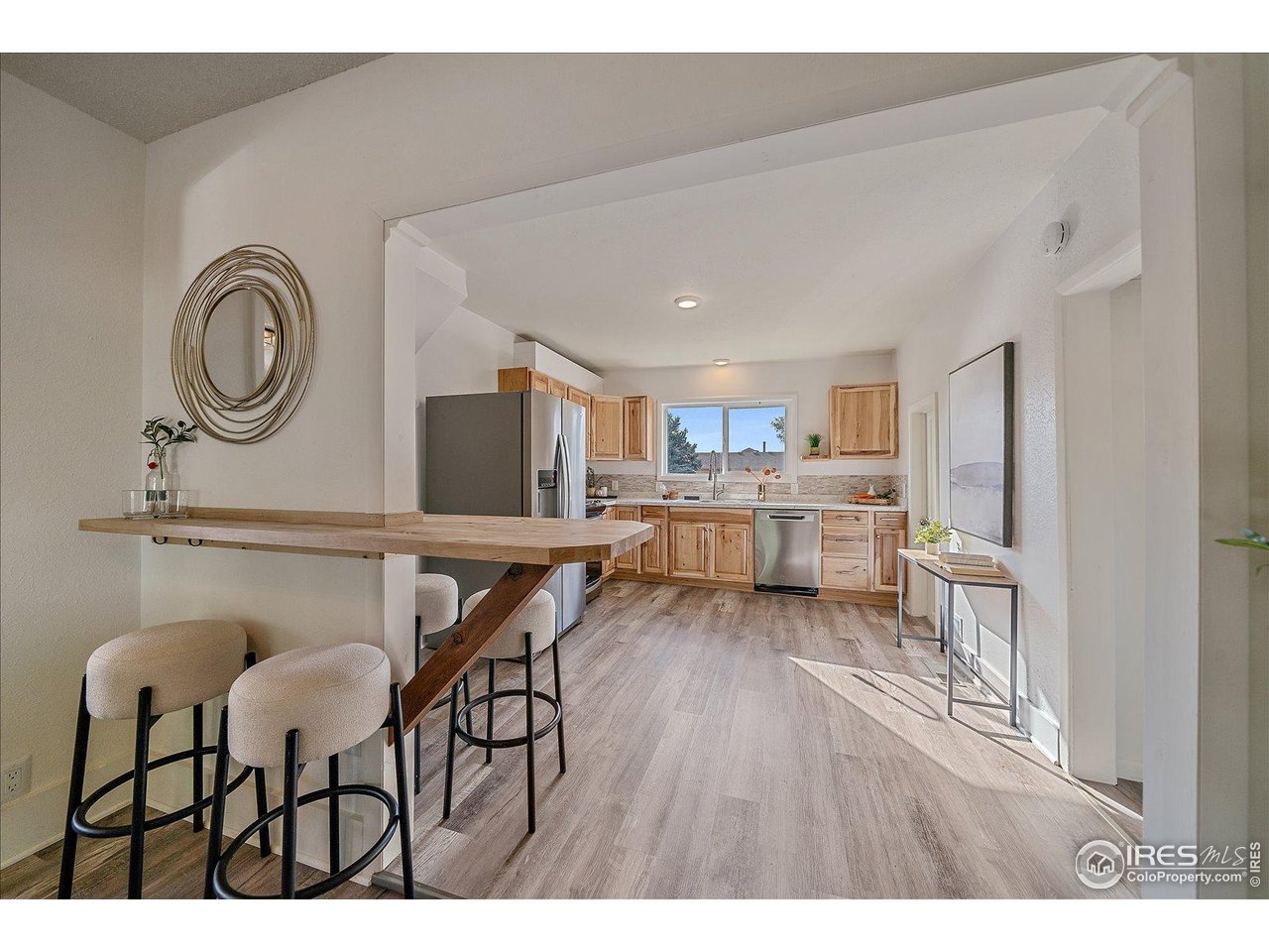 131 3rd Street Dacono, CO 80514 - Photo 9 of 28 a living room with kitchen island furniture and a wooden floor