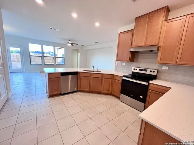 a kitchen with stainless steel appliances granite countertop a stove sink and cabinets