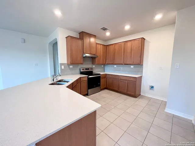 a kitchen with a sink a stove a microwave and cabinets