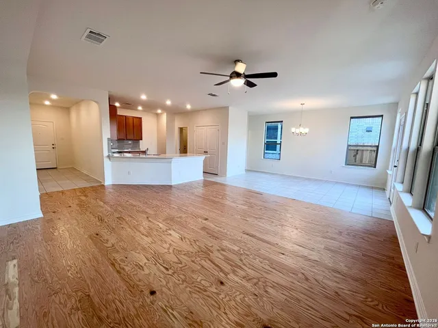 a view of a big room with wooden floor and windows