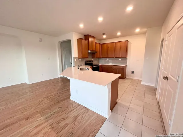 a view of kitchen with cabinets microwave and stove