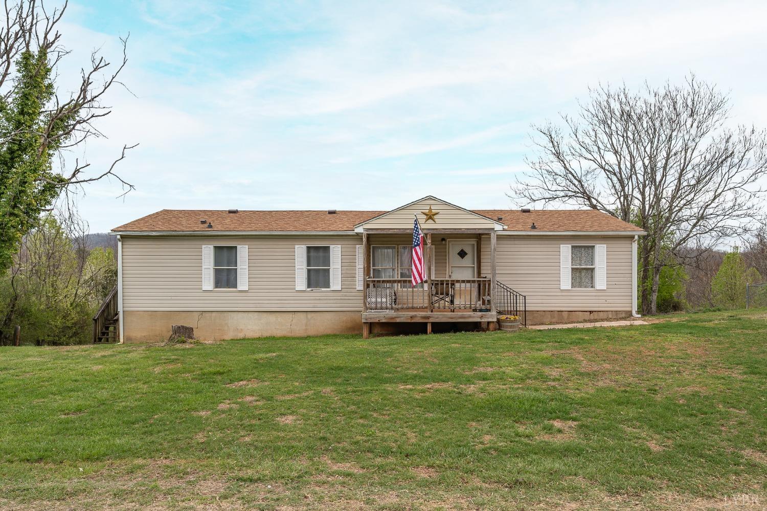 1105 Veteran Road Vinton, VA 24179 - Photo 1 of 37 a front view of a house with a garden and trees