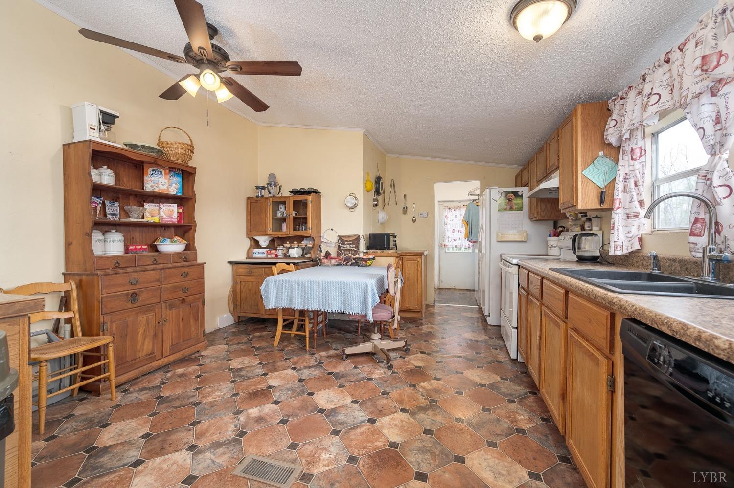 1105 Veteran Road Vinton, VA 24179 - Photo 11 of 37 a large kitchen with stainless steel appliances a stove a chimney a dining table and chairs
