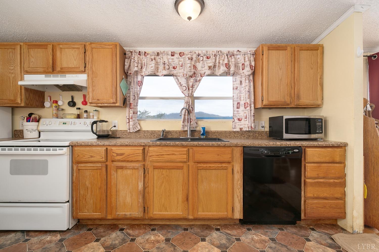 1105 Veteran Road Vinton, VA 24179 - Photo 12 of 37 a kitchen with stainless steel appliances granite countertop a stove a sink and a refrigerator