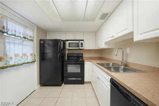 a kitchen with granite countertop white cabinets and stainless steel appliances