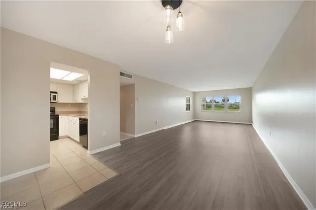 a living room with furniture a chandelier and a dining table