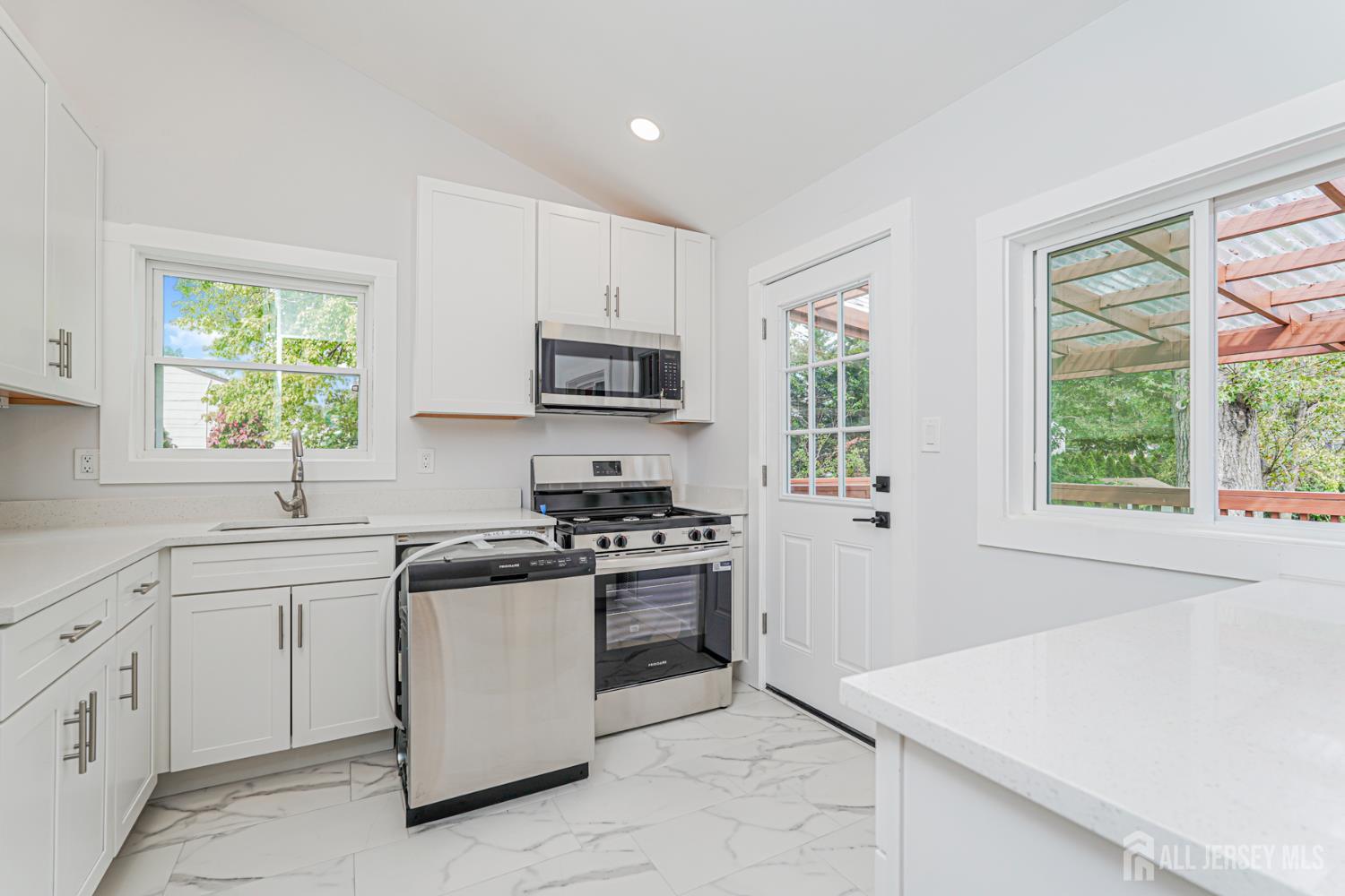 20 Daniel Road Spotswood, NJ 08884 - Photo 11 of 29 a kitchen with white cabinets appliances a sink and a window