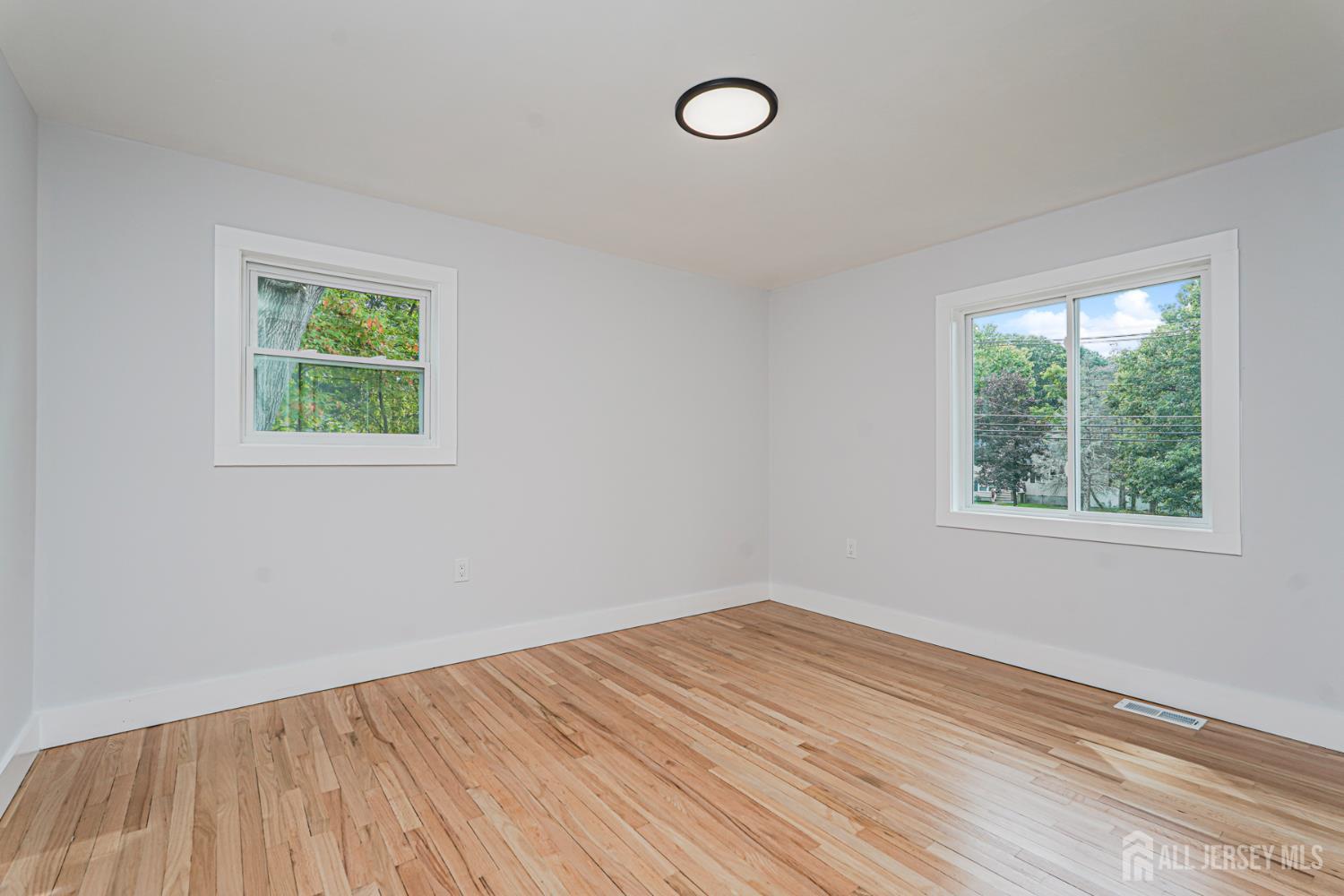 20 Daniel Road Spotswood, NJ 08884 - Photo 17 of 29 an empty room with wooden floor and windows