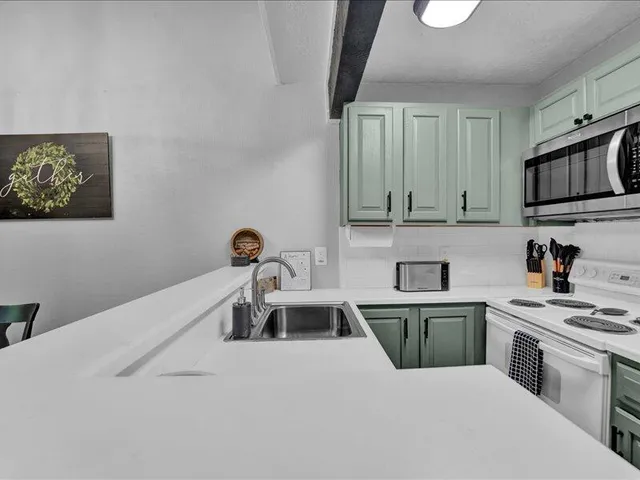 a kitchen with kitchen island a sink stainless steel appliances and cabinets