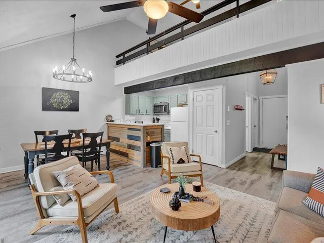 a living room with furniture a rug and kitchen view