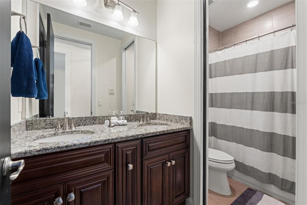 4387 Harborpointe Drive Port Richey, FL 34668 - Photo 41 of 46 a bathroom with a granite countertop sink a toilet and a shower