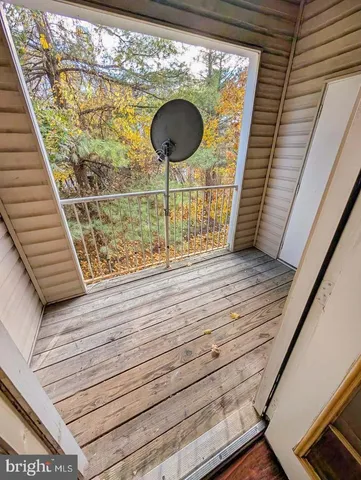 an empty room with wooden floor chandelier fan and windows