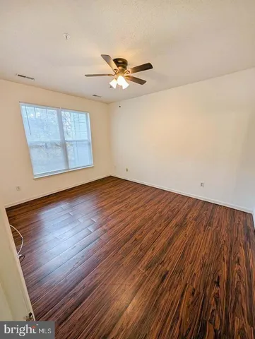 a view of a room with wooden floor and fan
