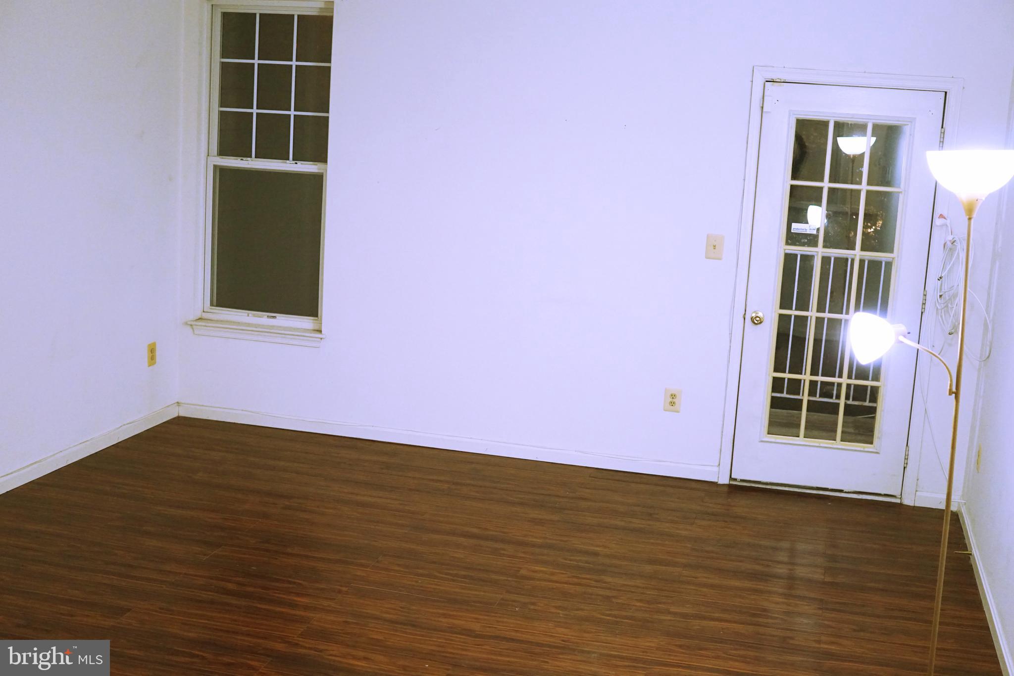 7115 Sandown Circle, Unit 202 Windsor Mill, MD 21244 - Photo 28 of 58 a view of an empty room with a window and wooden floor