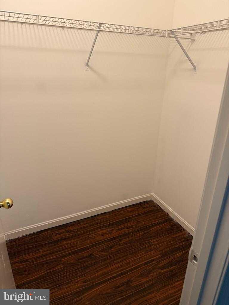 7115 Sandown Circle, Unit 202 Windsor Mill, MD 21244 - Photo 35 of 58 a view of a room with wooden floor and white walls