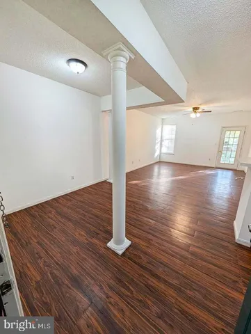 a view of empty room with wooden floor