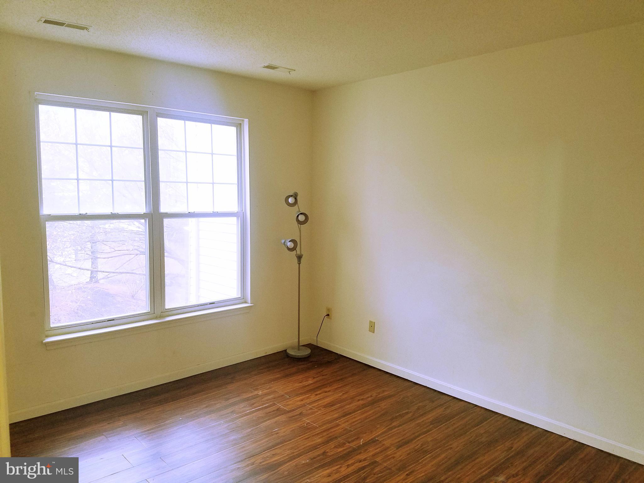 7115 Sandown Circle, Unit 202 Windsor Mill, MD 21244 - Photo 8 of 58 an empty room with wooden floor and windows