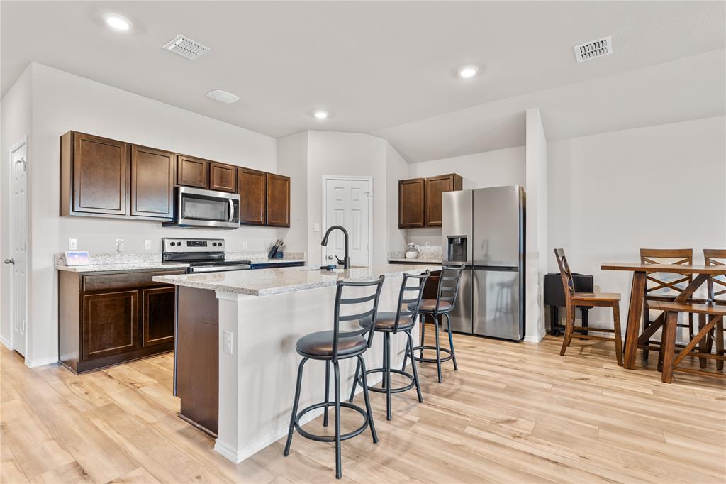 7100 Canadian Drive China Spring, TX 76633 - Photo 4 of 16 a kitchen with kitchen island granite countertop wooden cabinets and stainless steel appliances
