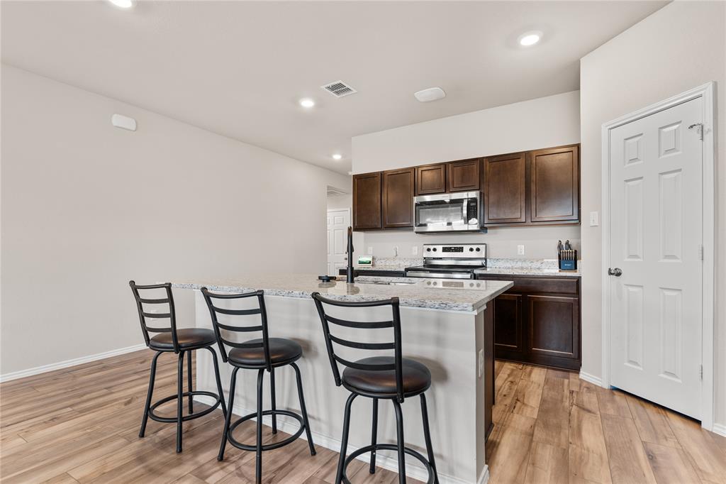7100 Canadian Drive China Spring, TX 76633 - Photo 6 of 16 a kitchen with a table chairs microwave and cabinets