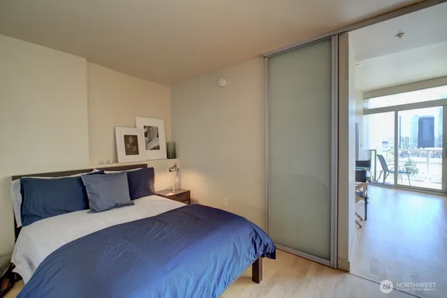 a bedroom with a bed and wooden floor