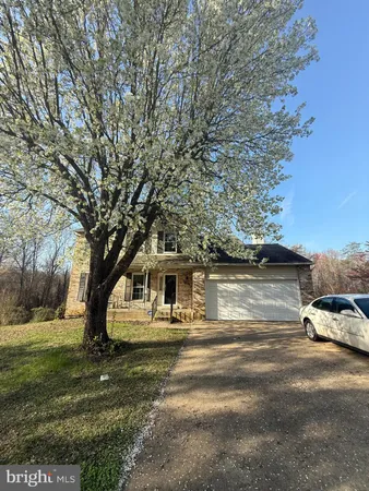 a white house that has tree in front of it