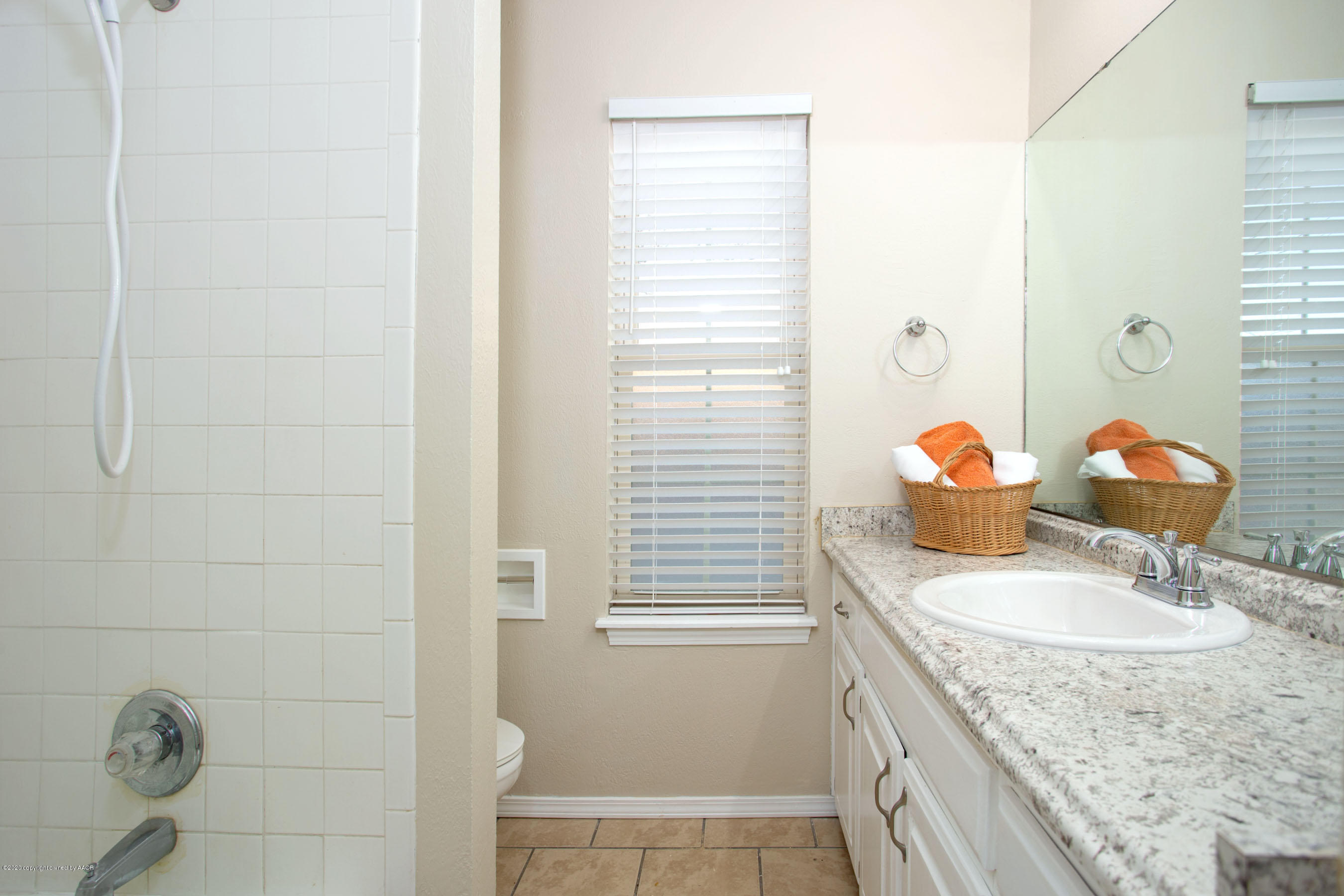 5104 Pin Oak Drive Amarillo, TX 79110 - Photo 17 of 20 a bathroom with a granite countertop sink a toilet a mirror and shower