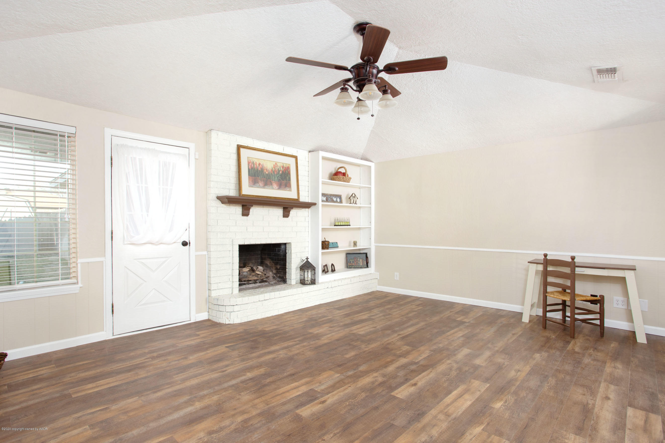 5104 Pin Oak Drive Amarillo, TX 79110 - Photo 5 of 20 a view of a livingroom with a fireplace a ceiling fan and wooden floor