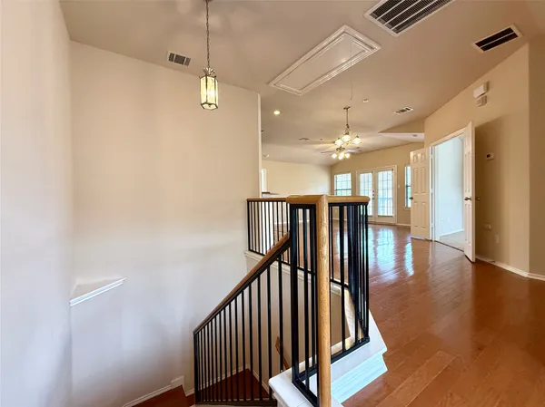 a view of an empty room with wooden floor and a large window