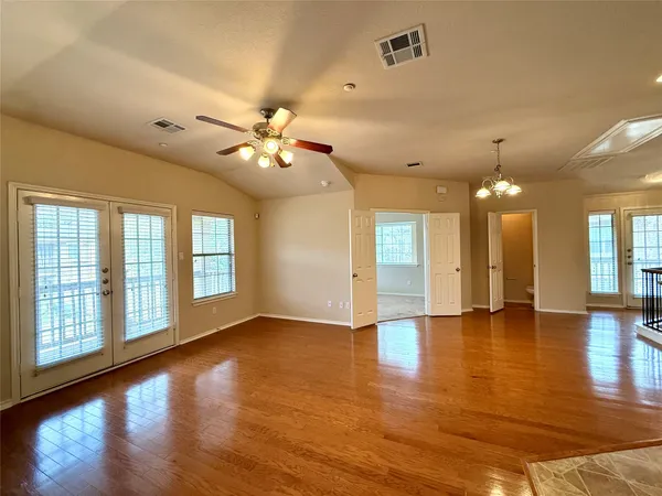 a view of a hallway with entryway and wooden floor