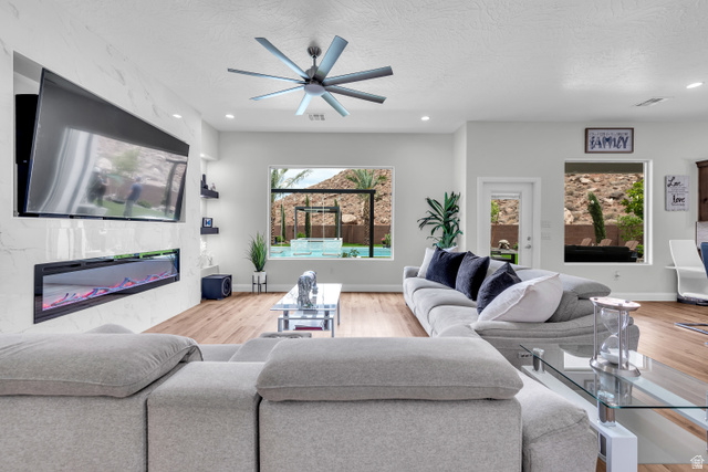 6105 Bunda Way St. George, UT 84790 - Photo 6 of 49 Living area featuring a modern linear electric fireplace, wood-finish flooring, recessed lighting, and a contemporary ceiling fan