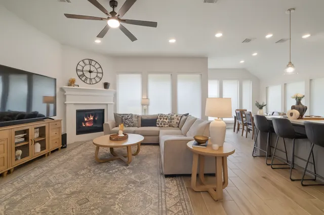 a living room with furniture and a view of kitchen