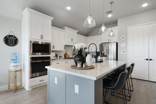 a kitchen with white cabinets and appliances
