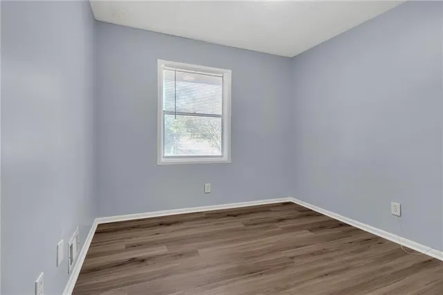a view of a room with wooden floor and windows