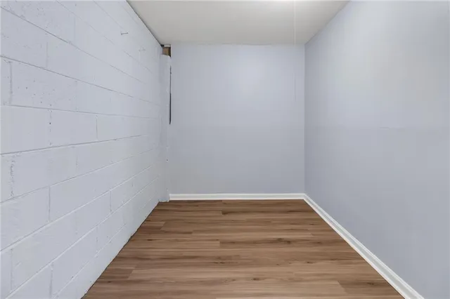 a view of a room with wooden floor and brick wall