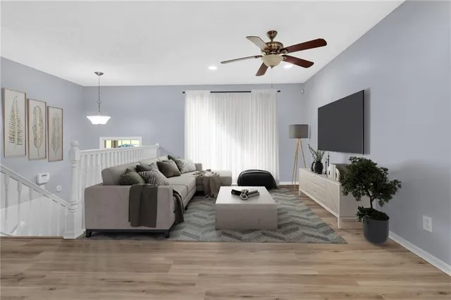 a living room with furniture potted plant and a flat screen tv