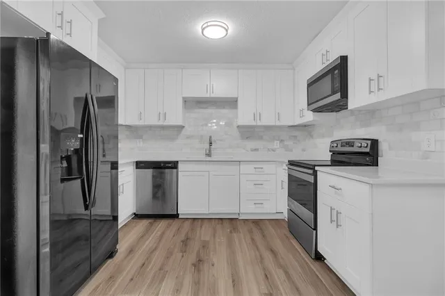 a kitchen with a refrigerator stove and white cabinets