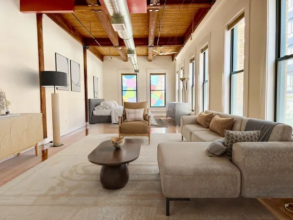 a living room with furniture a lamp and a large window
