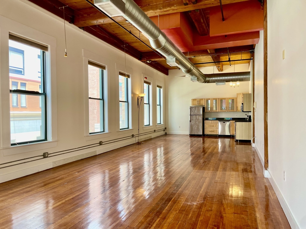 49 Munroe Street, Unit 201 Lynn, MA 01901 - Photo 15 of 16 a view of an empty room with wooden floor and a window