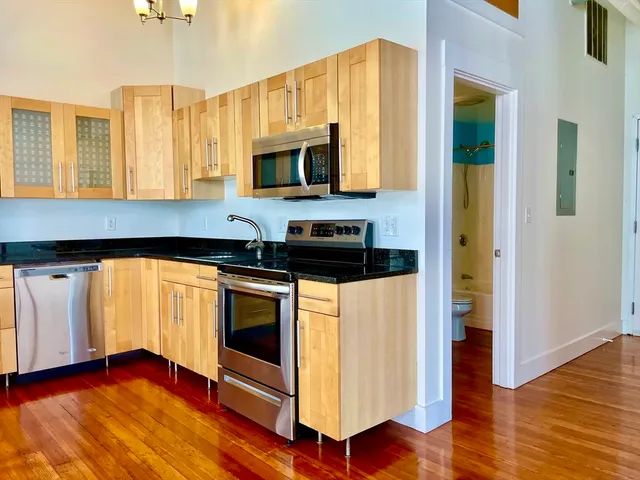 a kitchen with stainless steel appliances granite countertop a stove a sink and a microwave