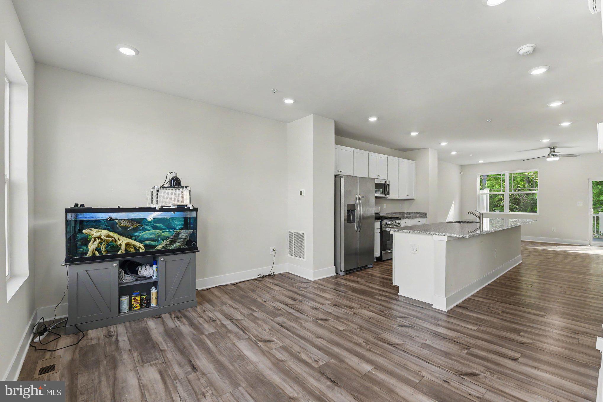 238 Waterstone Road Essex, MD 21221 - Photo 11 of 39 a kitchen with stainless steel appliances kitchen island wooden floors and white cabinets