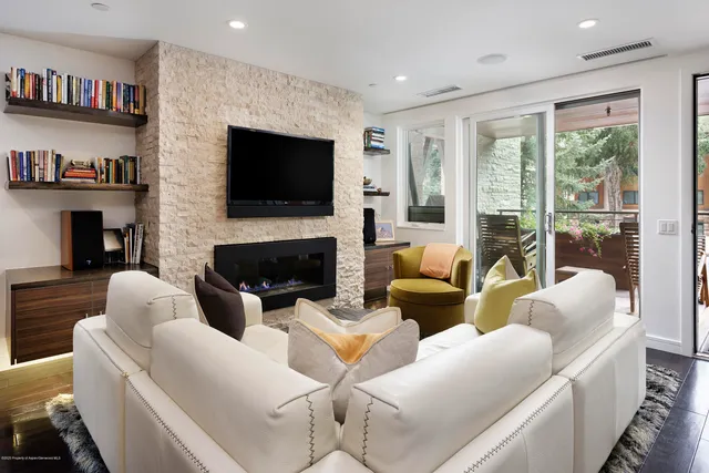a living room with furniture a flat screen tv and a fireplace