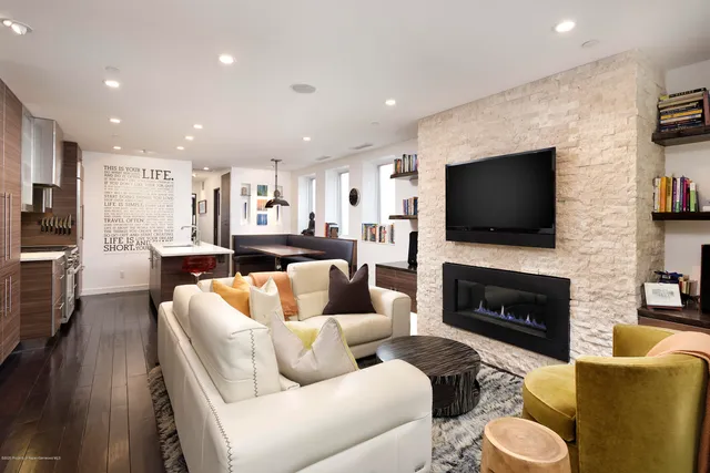 a living room with furniture a flat screen tv and a fireplace