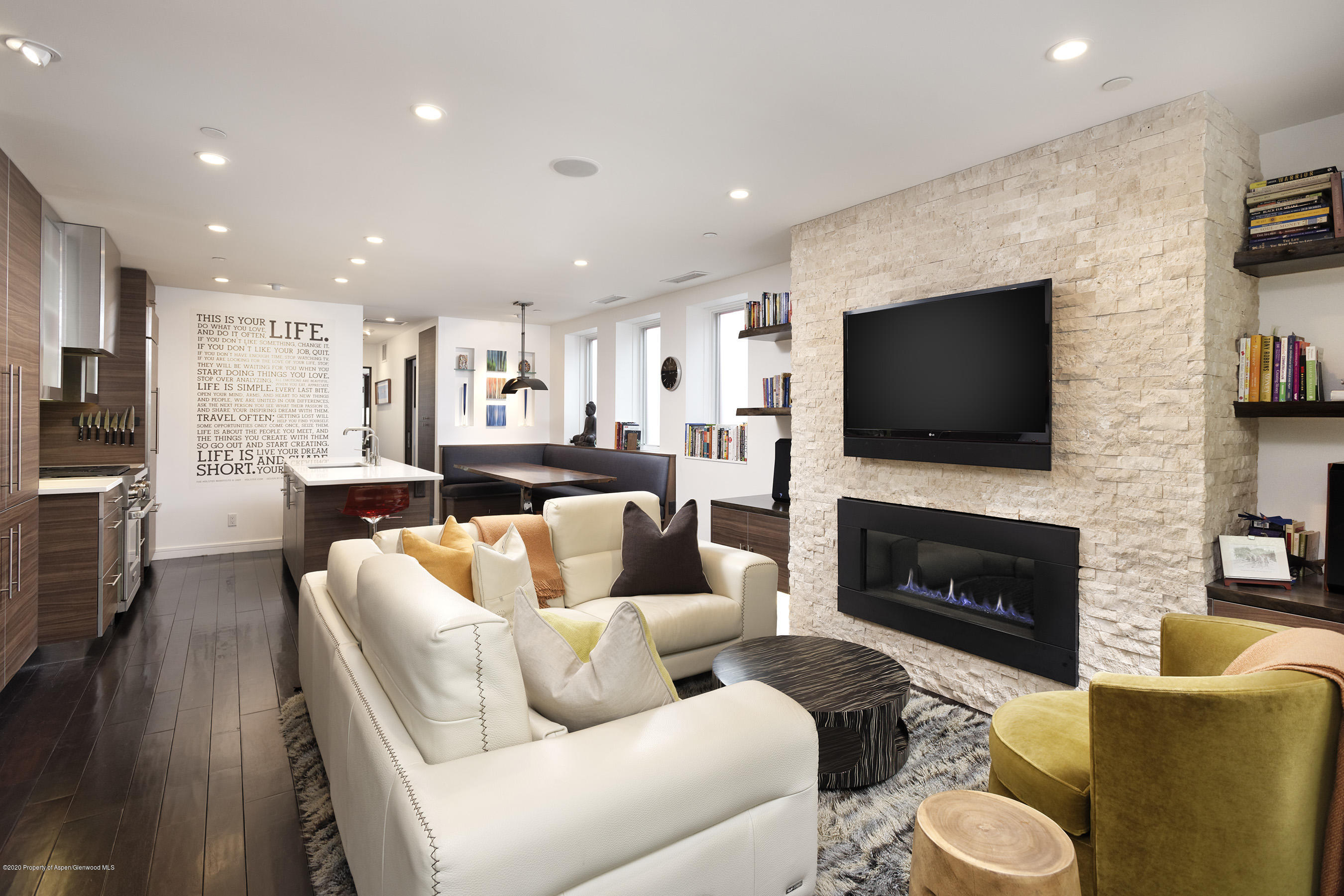 100 East Cooper Avenue, Unit 12 Aspen, CO 81611 - Photo 3 of 12 a living room with furniture a flat screen tv and a fireplace