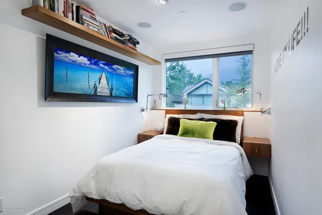 a bedroom with a bed and a painting on the wall