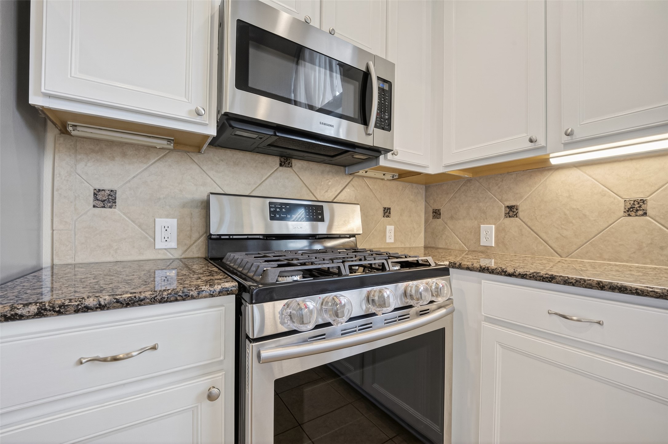 3219 Legends Mist Drive Spring, TX 77386 - Photo 18 of 37 a kitchen with stainless steel appliances granite countertop white cabinets and a stove top oven with granite countertops