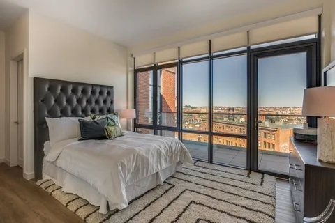 a bedroom with a large window and a balcony
